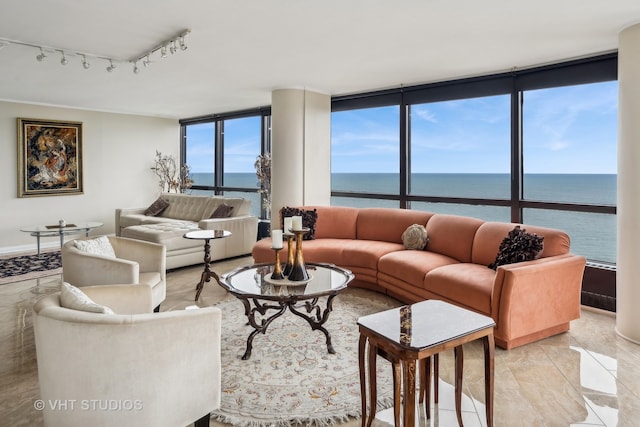 tiled living room with a wall of windows, a water view, and track lighting