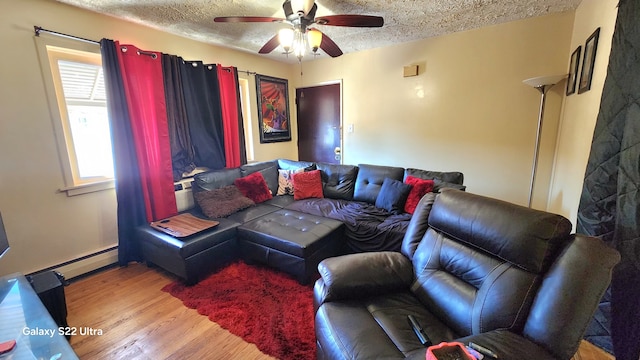 living room with light hardwood / wood-style flooring, a textured ceiling, a baseboard heating unit, and ceiling fan