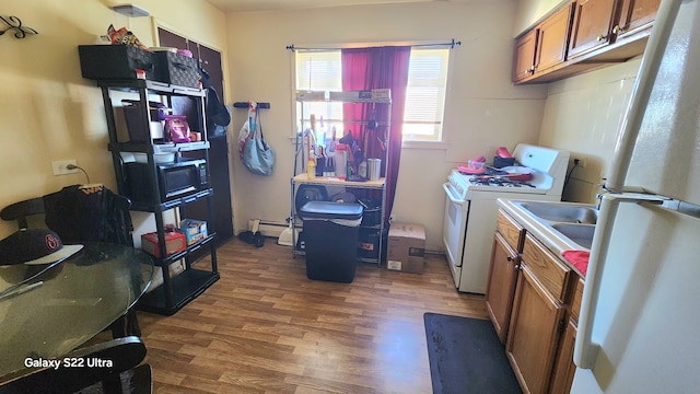 clothes washing area featuring washer and dryer, dark hardwood / wood-style flooring, and a baseboard heating unit