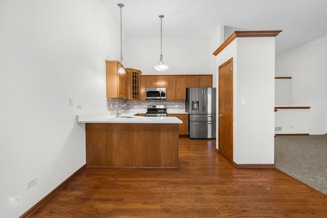 kitchen with dark hardwood / wood-style floors, sink, kitchen peninsula, appliances with stainless steel finishes, and decorative light fixtures