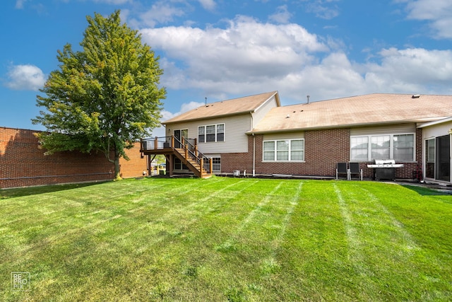 back of property with a lawn, a wooden deck, and a patio