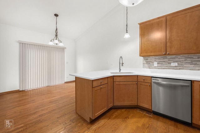 kitchen with pendant lighting, light wood-type flooring, sink, and stainless steel dishwasher