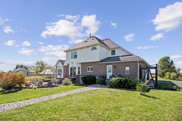 rear view of property featuring a lawn and a patio area