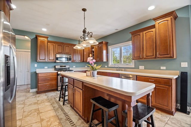 kitchen with sink, decorative light fixtures, appliances with stainless steel finishes, a center island, and a kitchen bar