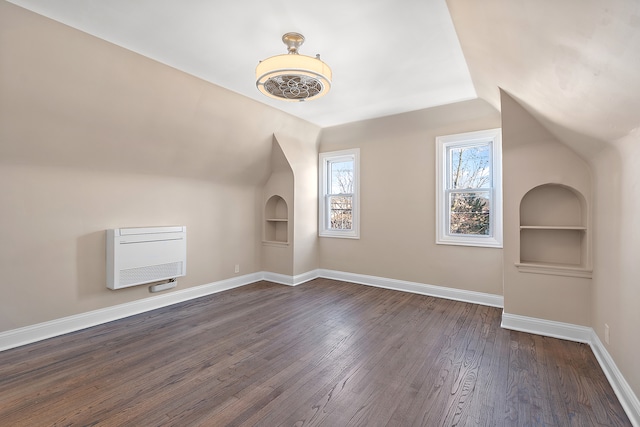 bonus room featuring dark hardwood / wood-style flooring, lofted ceiling, and built in features