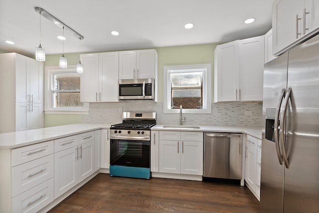 kitchen featuring plenty of natural light, sink, white cabinetry, kitchen peninsula, and stainless steel appliances