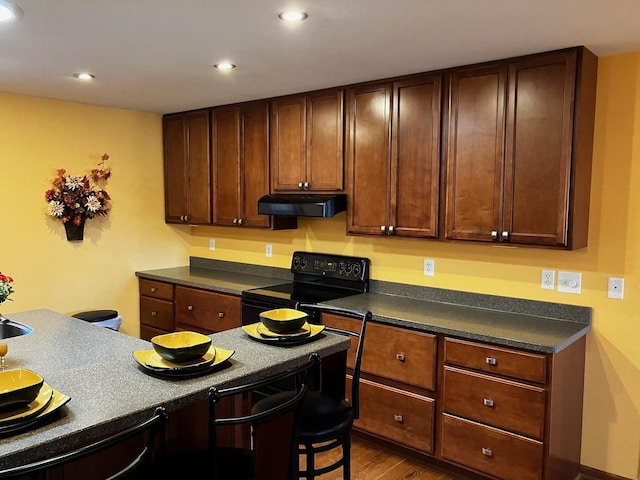 kitchen featuring black electric range oven and hardwood / wood-style floors