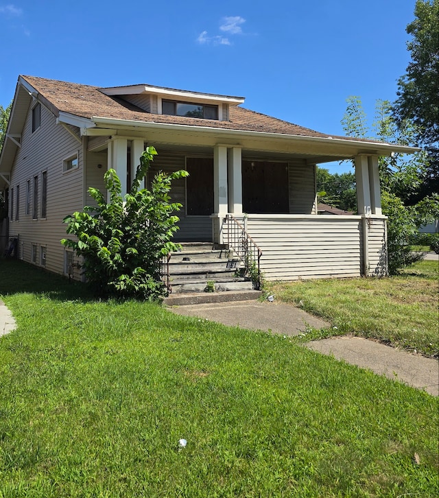 view of front of property with covered porch and a front yard