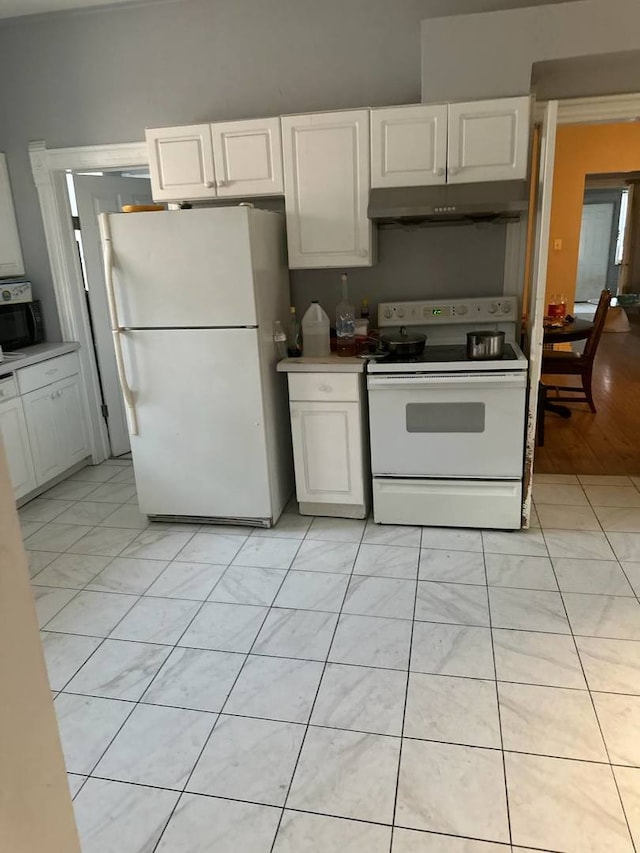 kitchen with white cabinets, light hardwood / wood-style flooring, and white appliances