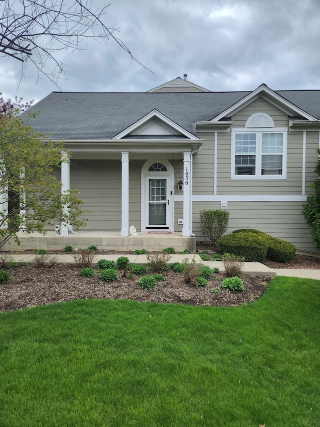 view of front of home with covered porch and a front lawn