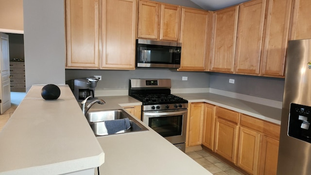 kitchen with light brown cabinetry, sink, light tile patterned floors, and appliances with stainless steel finishes