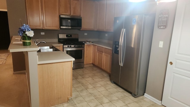 kitchen with kitchen peninsula, appliances with stainless steel finishes, and sink