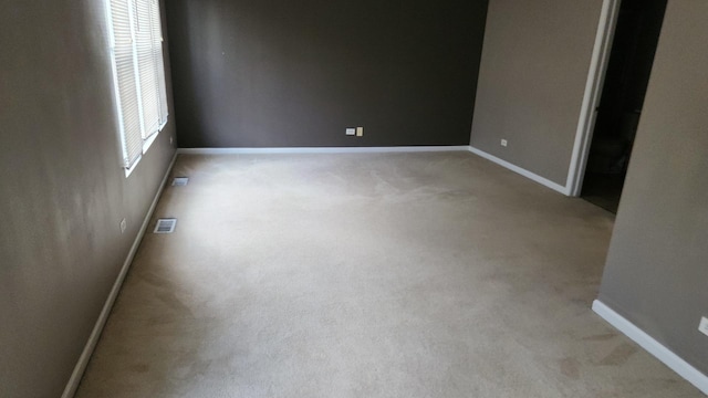 spare room featuring light colored carpet