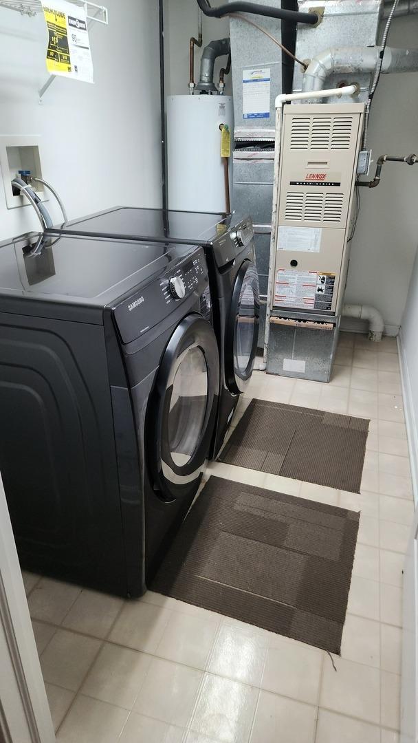 washroom with separate washer and dryer, heating unit, and water heater