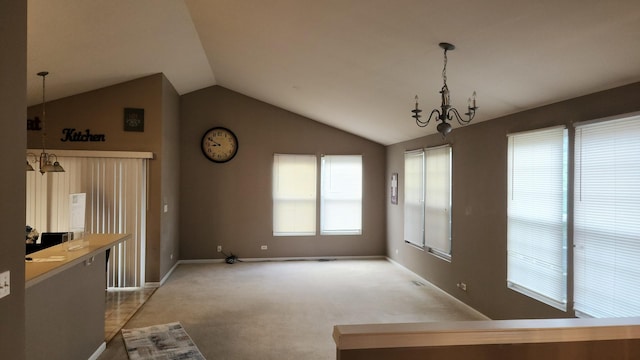 unfurnished dining area featuring carpet floors, an inviting chandelier, and vaulted ceiling