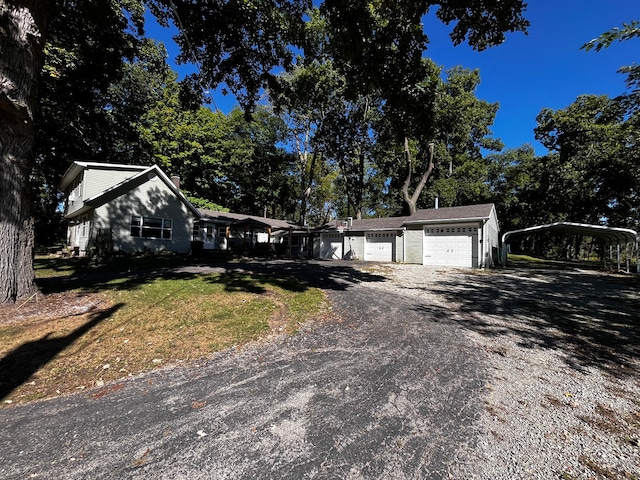 view of front facade featuring a carport, a garage, and a front yard