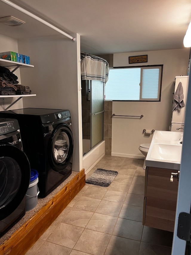 laundry room with washer and clothes dryer, sink, and tile patterned floors