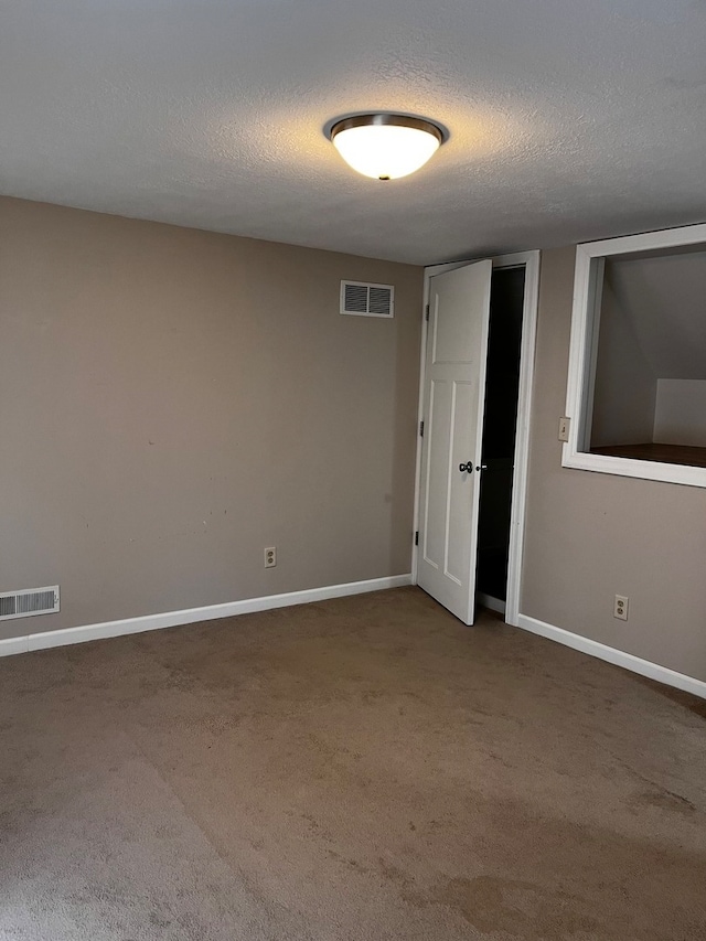 carpeted spare room with a textured ceiling