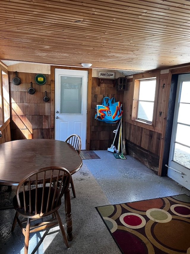 dining space featuring wood ceiling and wood walls