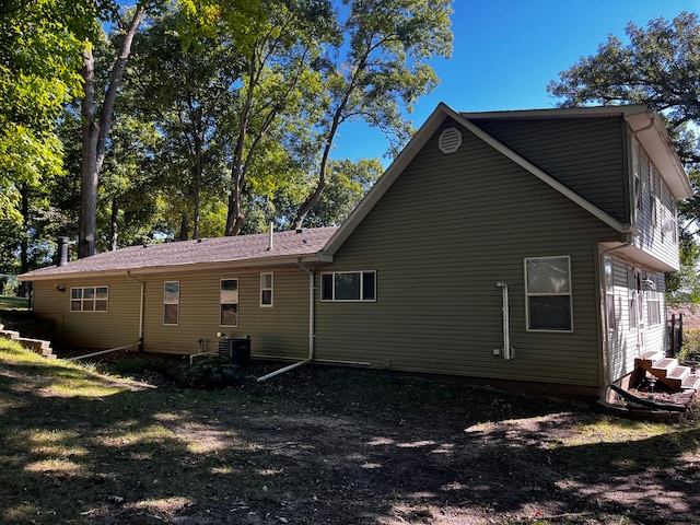 back of property with cooling unit and a yard