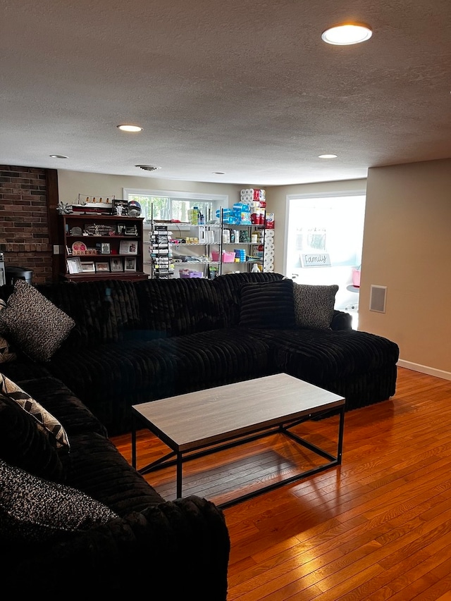 living room with a textured ceiling and wood-type flooring