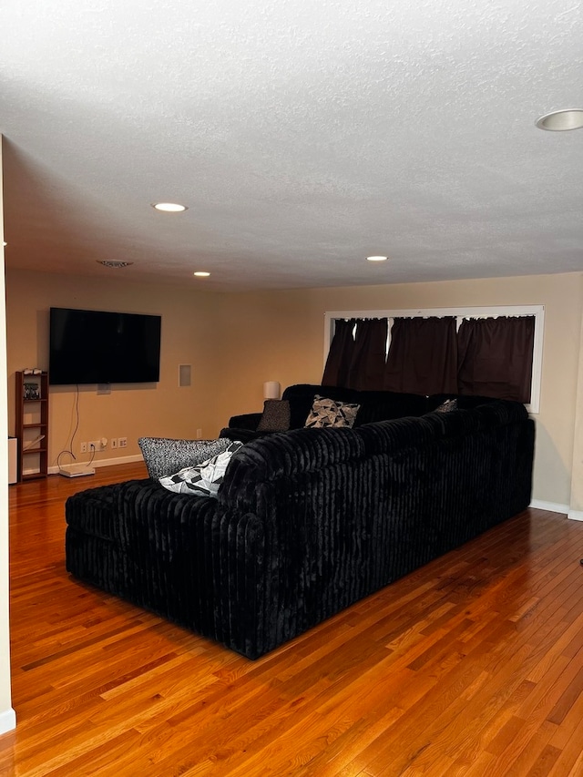 living room featuring a textured ceiling and hardwood / wood-style floors