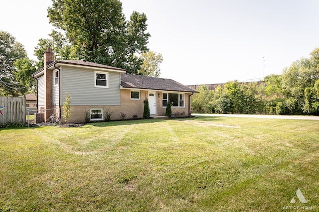 rear view of house featuring a lawn and central AC