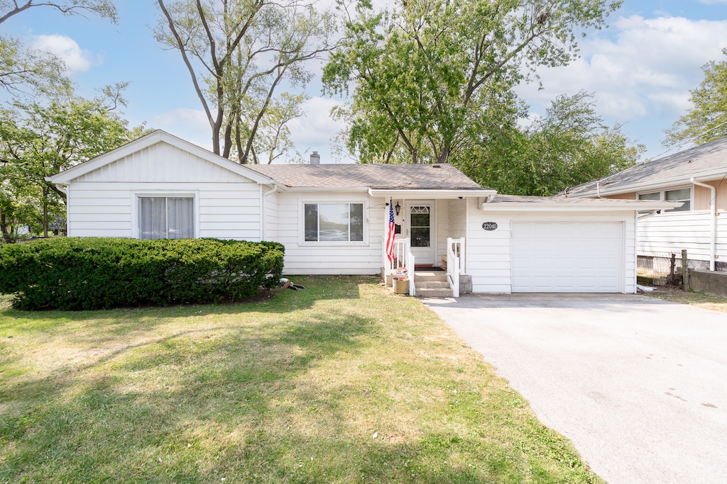 ranch-style house featuring a front lawn and a garage