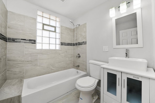 full bathroom featuring vanity, tile patterned flooring, toilet, and tiled shower / bath combo