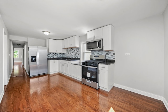 kitchen with white cabinetry, sink, appliances with stainless steel finishes, backsplash, and dark wood-type flooring