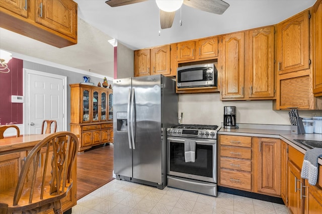 kitchen with crown molding, appliances with stainless steel finishes, light wood-type flooring, and ceiling fan