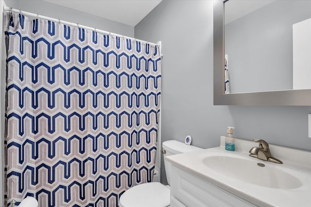 bathroom featuring vanity, toilet, and curtained shower