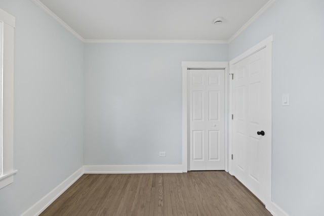 unfurnished room featuring crown molding and wood-type flooring