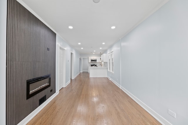 hall with crown molding and light hardwood / wood-style flooring