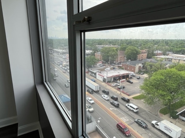 doorway to outside with a view of city and baseboards