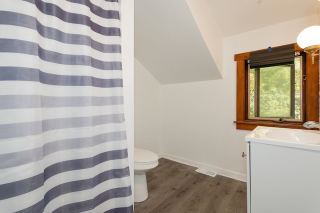 bathroom featuring toilet, vanity, vaulted ceiling, and hardwood / wood-style flooring