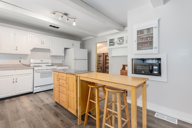 kitchen featuring a breakfast bar, white appliances, beam ceiling, white cabinets, and light hardwood / wood-style floors