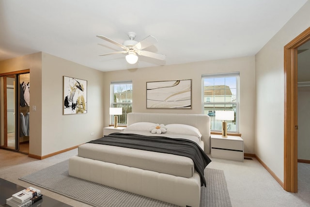 bedroom featuring ceiling fan, multiple windows, light carpet, and a closet