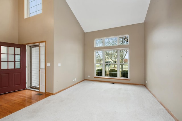 entryway featuring a towering ceiling and carpet floors