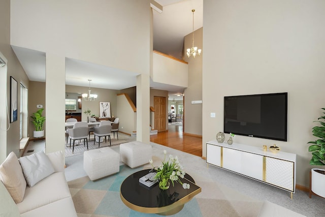 living room with carpet, a chandelier, and a high ceiling