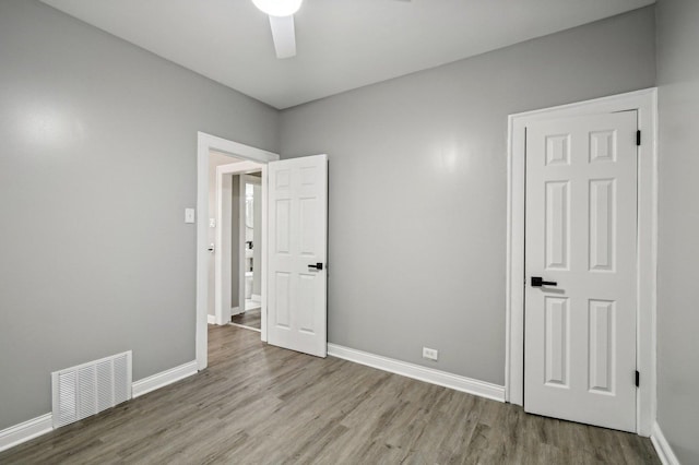 empty room with ceiling fan and light hardwood / wood-style floors