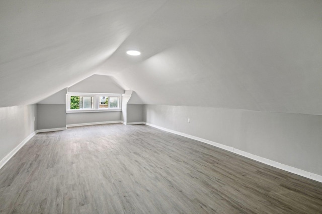 bonus room with lofted ceiling and dark wood-type flooring