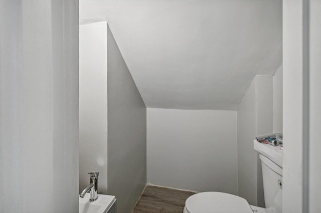 bathroom featuring hardwood / wood-style floors, toilet, and lofted ceiling