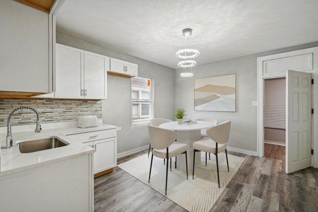 kitchen featuring backsplash, white cabinetry, dark wood-type flooring, and sink