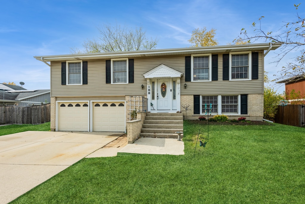 raised ranch featuring a front yard and a garage