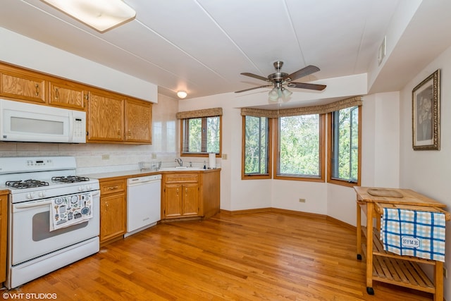 kitchen with a healthy amount of sunlight, white appliances, and light hardwood / wood-style flooring