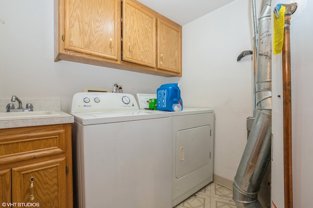 laundry area featuring separate washer and dryer, sink, and cabinets