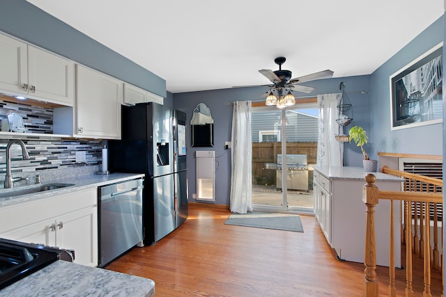 kitchen featuring light hardwood / wood-style flooring, ceiling fan, stainless steel appliances, and white cabinets