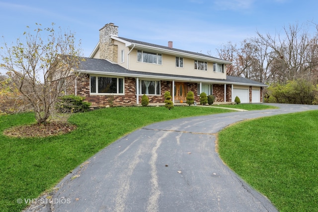 view of front of property featuring a garage and a front lawn