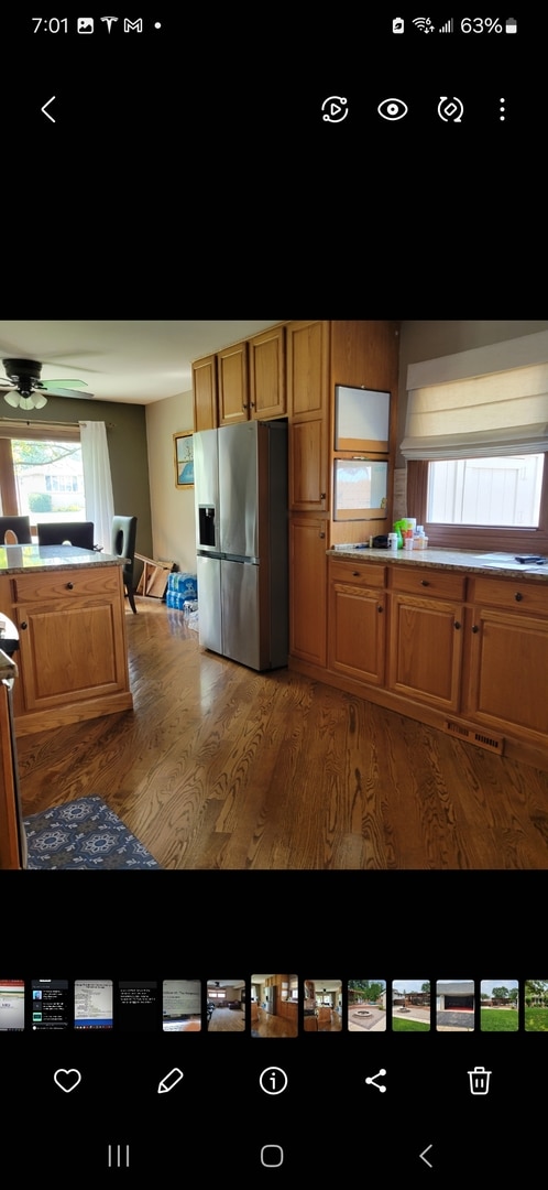 kitchen with ceiling fan, light wood-type flooring, and stainless steel fridge with ice dispenser